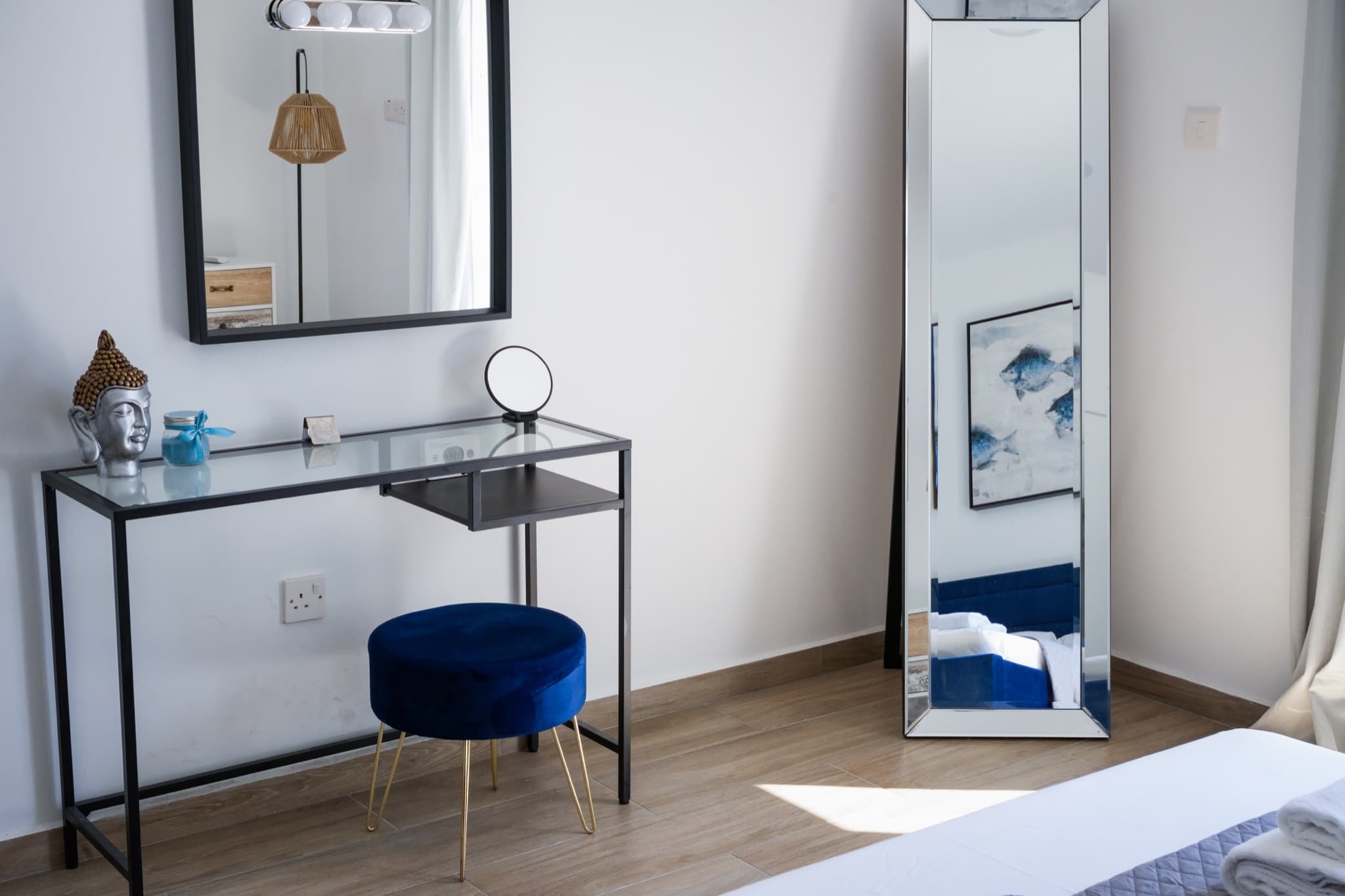 Glass vanity desk with blue stool, wall mirror, and full-length mirror