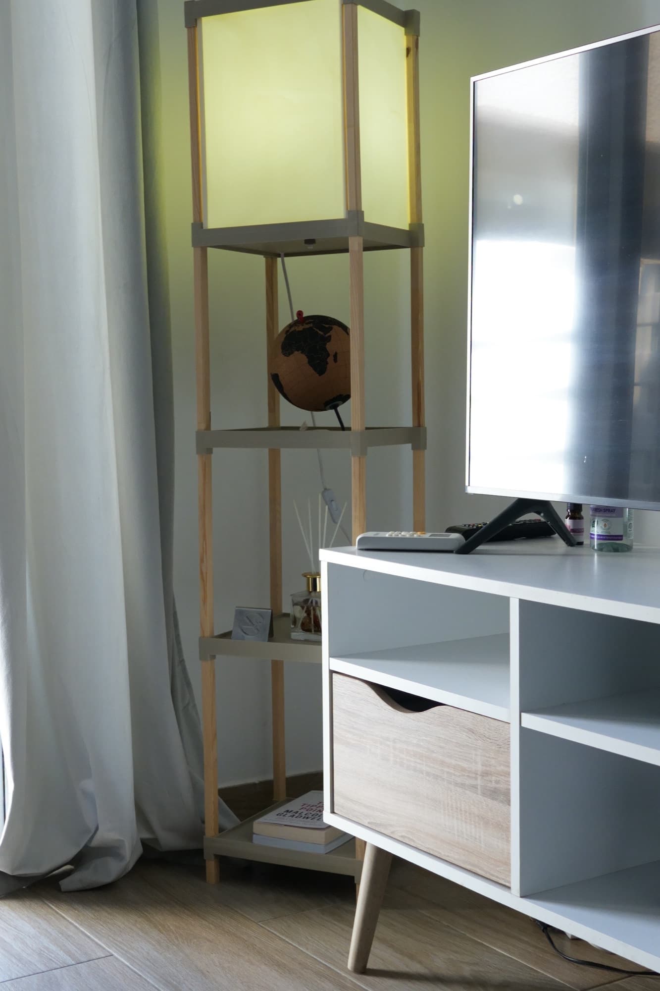 Overhead view of bedroom corner with white cube storage unit and wooden shelf
