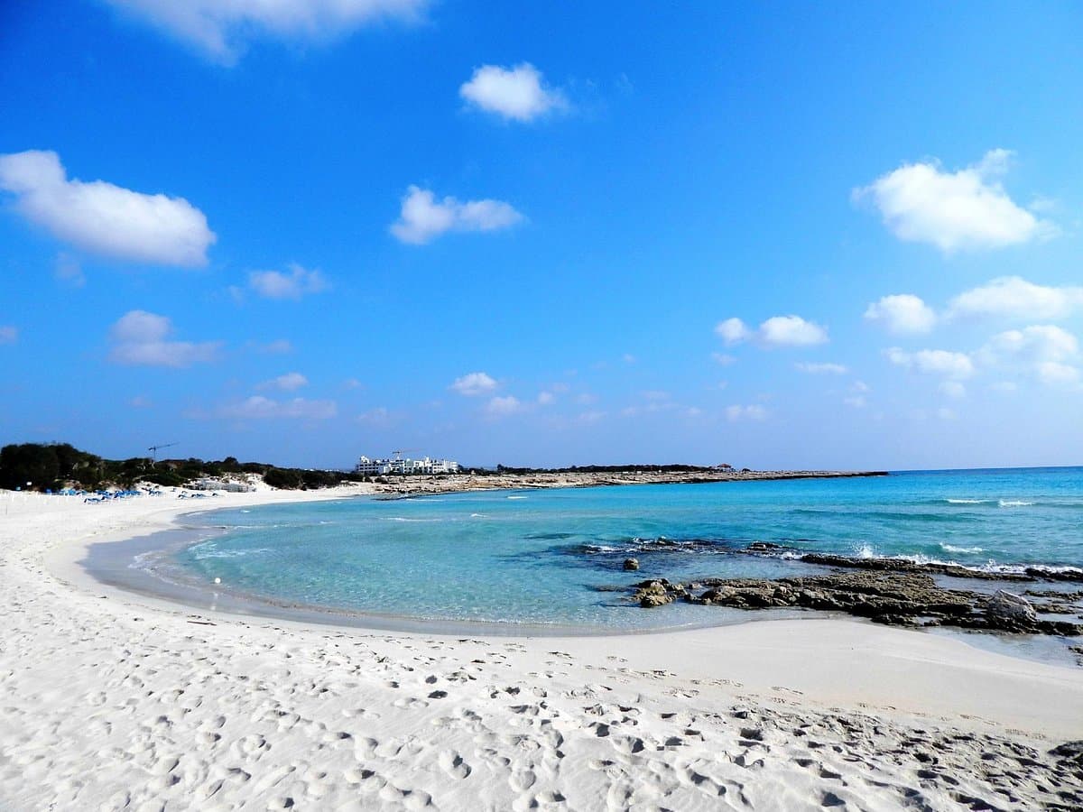 Curved white sand shoreline and turquoise cove at Landa Beach
